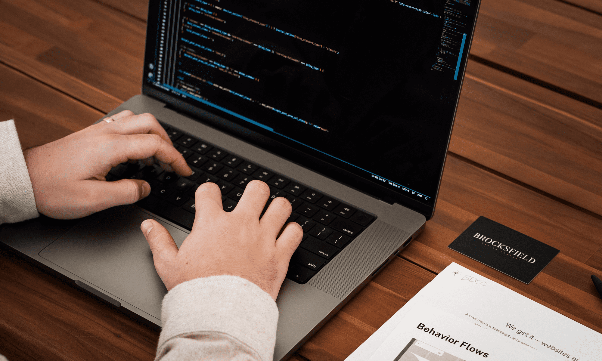 Close-up of web development work at Brocksfield Design Company with code displayed on a laptop screen, highlighting website optimization and coding practices.